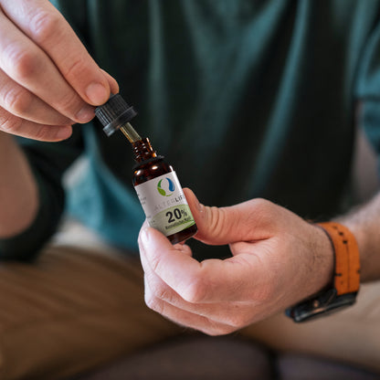 Person tropft ALTERLIFE 20% CBD Öl aus der Pipettenflasche