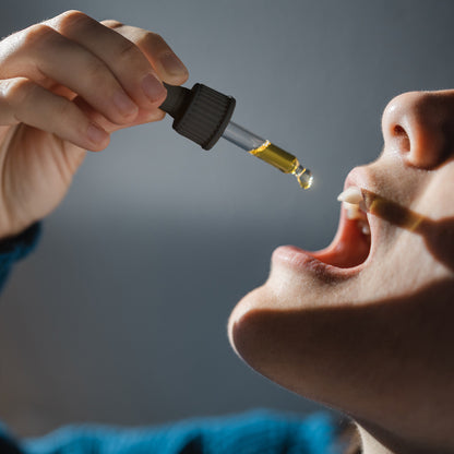 Einnahme von CBD Öl Tropfen unter die Zunge mit Pipette
